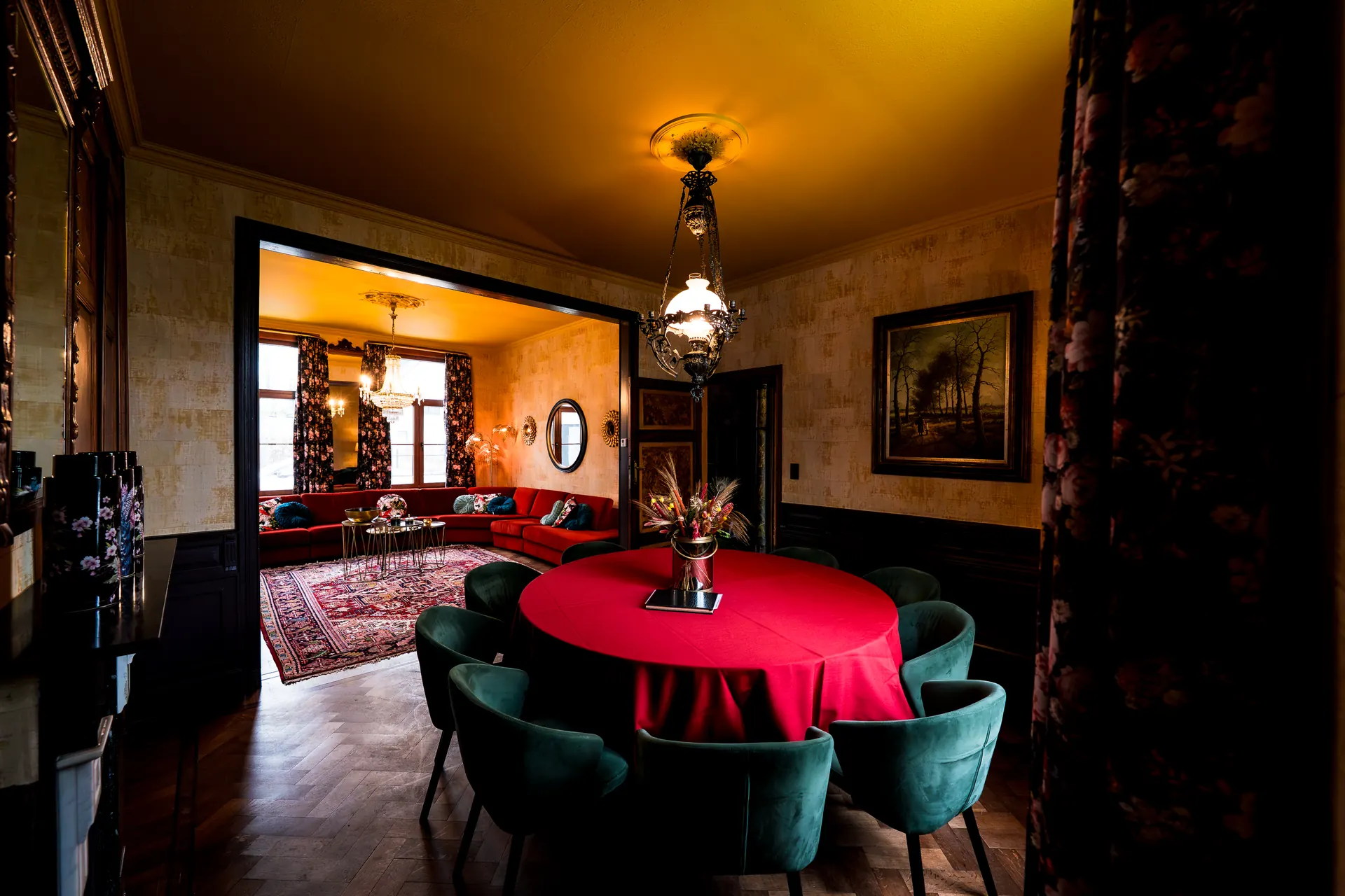 Eetkamer met rode tafel in een vakantiewoning in het Meetjesland